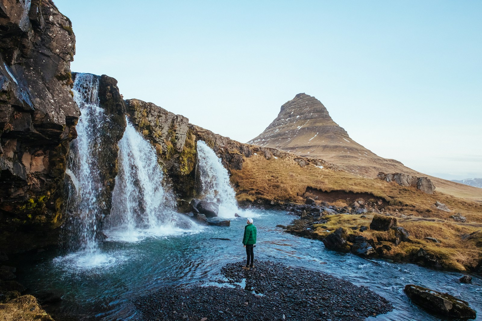 man standing near waterfalls
